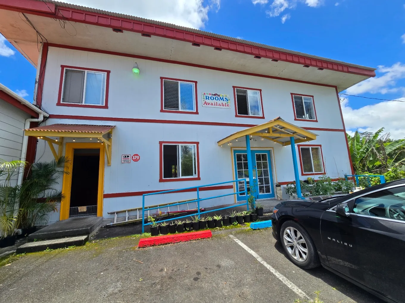 The Rooms building at Ōhi'a Lehua Inn — white with red trim, rooms available